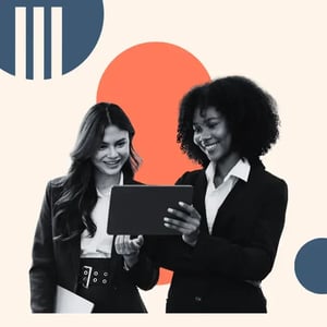 Two women smile at laptop